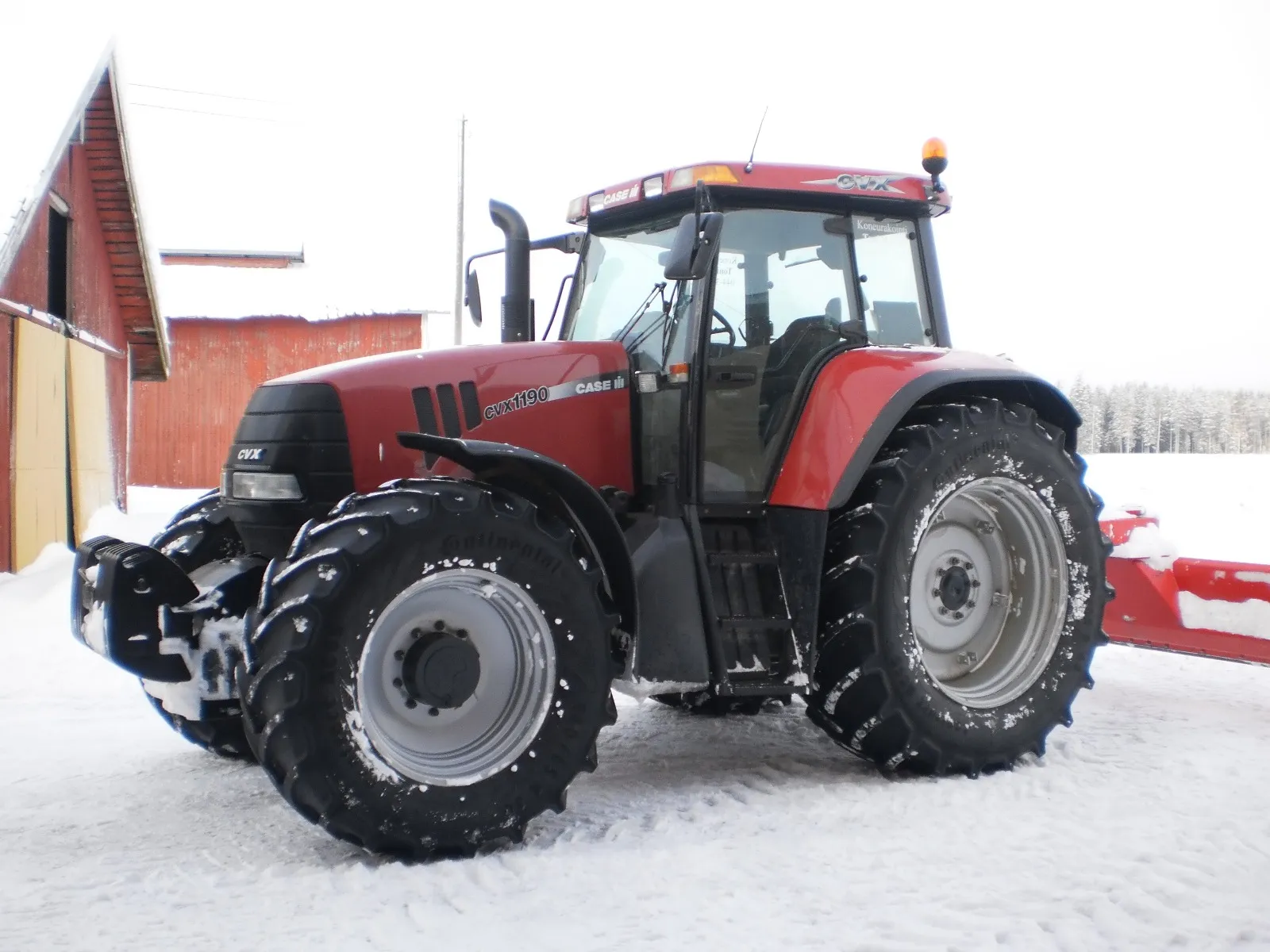 Punainen Case CVX 1190 -traktori lumisella pihamaalla talvimaisemassa.