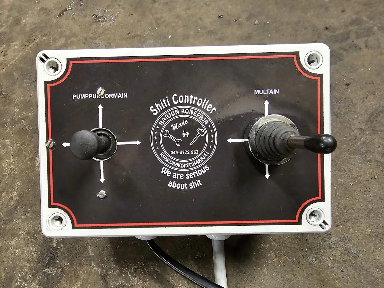 Ohjauskotelo, jossa kaksi vipukytkintä ja tekstit pumppukuormain ja multain.